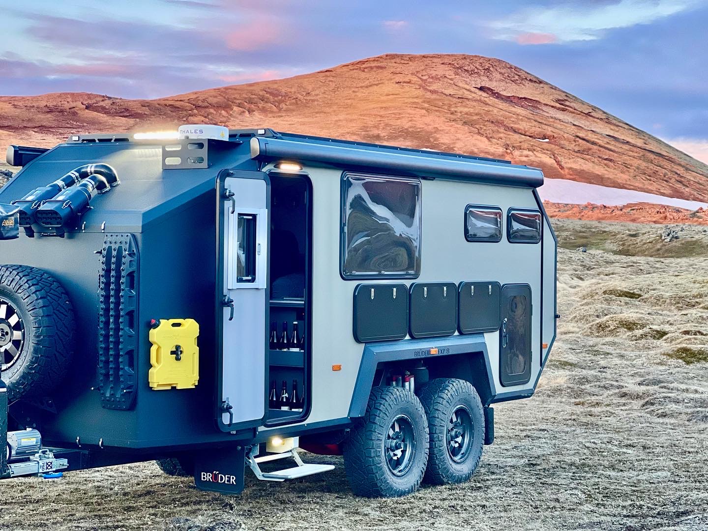 Bruder EXP-8 with side doors open camped below a volcanic ridge in Iceland